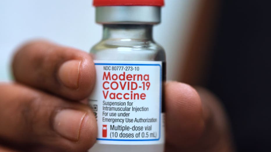 Dr. Salma Elfaki holds a vial of Moderna COVID-19 vaccine at