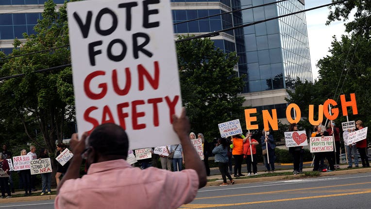 Man holds sign reading "Vote for gun safety"