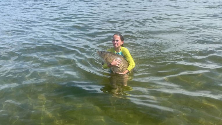 11-year-old Maddie Freese holds a carp she caught with her bare hands in Lake Minnetonka on Tuesday.