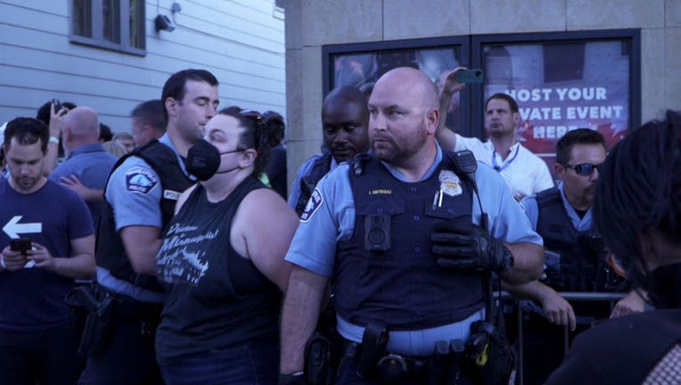 A Minneapolis Police Officer arrests protester Rachel Bean outside the Dave Chappelle show at the Varsity Theater in St. Paul on Friday, July 22.
