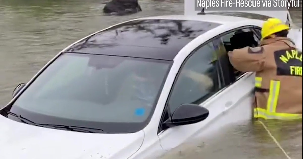 Watch: Firefighters smash car window to rescue woman from Ian ...