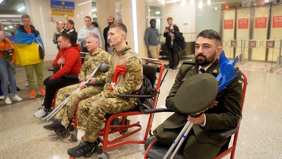 Two Ukrainian soldiers, Roman Matvisiv and Dimitro, are greeted by Ukranian-Americans and supporters as they arrive at the Minneapolis-St. Paul airport around midnight on Sunday, Oct. 28. Both would later be fitted with prosthetics from the Protez Foundation. (FOX 9)