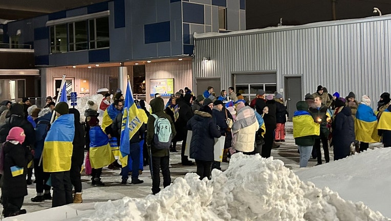 A crowd gathers in zero-degree wind chill at the Lowry Bridge in Minneapolis, which is lit up in Ukrainian blue and yellow, to mark the anniversary of Russia’s invasion of Ukraine