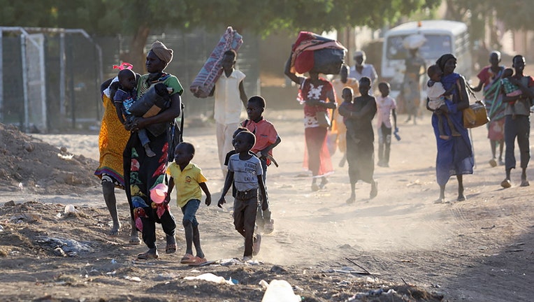 TOPSHOT - People flee their neighbourhoods amid fighting between the army and paramilitaries in Khartoum on April 19, 2023, following the collapse of a 24-hour truce. (Photo by AFP) (Photo by -/AFP via Getty Images)