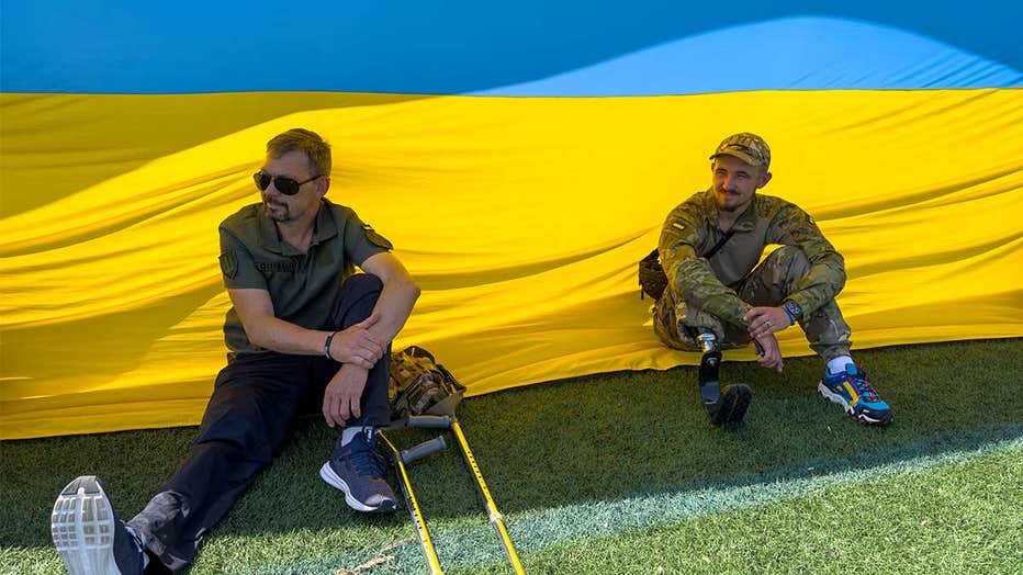 Ukrainian veterans, soon to receive prosthetics from the Protez Foundation, show support for the young players from FC Minaj during the USA Cup match in Blaine. (Photo courtesy of Family of Christ International)