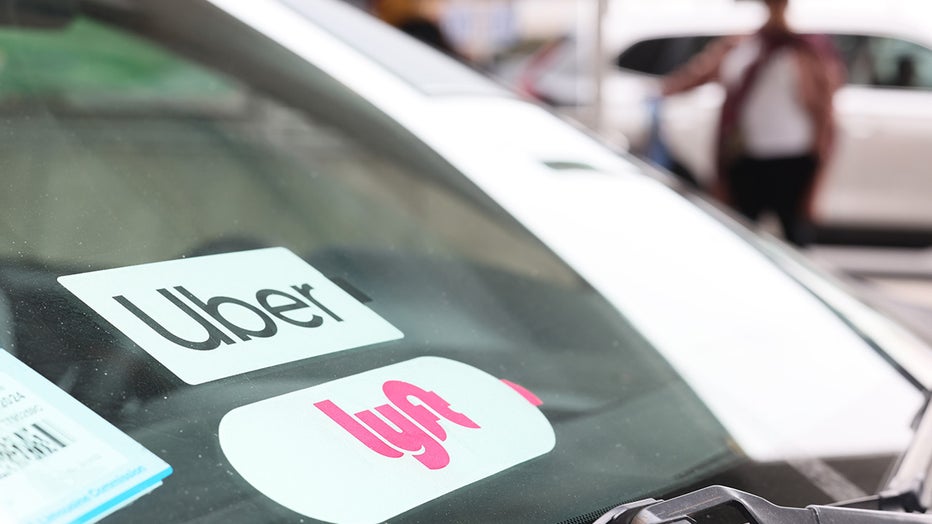 Lyft and Uber decals are seen on a car in the pick-up area at JFK Airport on April 28, 2023 in New York City. (Photo by Michael M. Santiago/Getty Images)