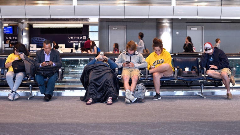 People-on-their-phones-in-the-airport.jpg