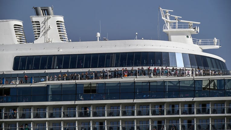 Tourists crowd upper decks and stateroom balconies as the Anthem of the Seas