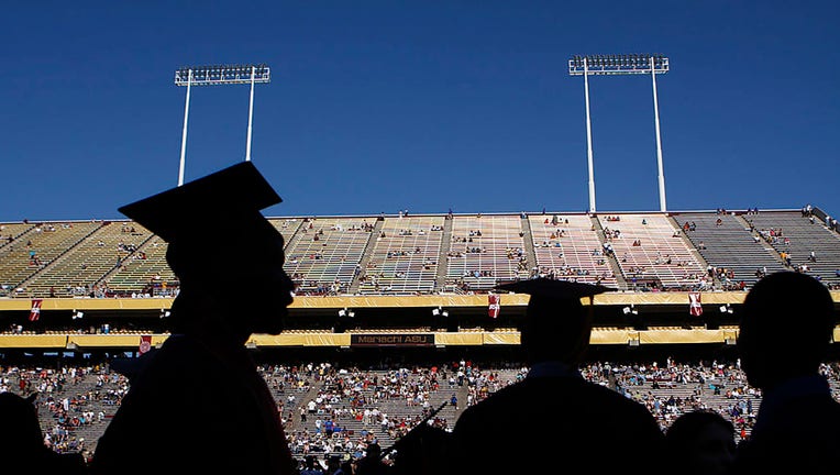 FILE - Arizona State University graduate students are silhouetted during their graduation at Sun Devil Stadium May 13, 2009, in Tempe, Arizona. (Photo by Joshua Lott/Getty Images)