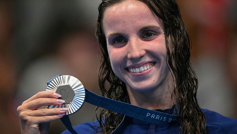 Smith smiles on the podium and holds up her silver medal.