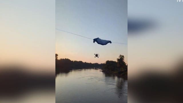 Paraglider strikes power line, crashes into river: Video