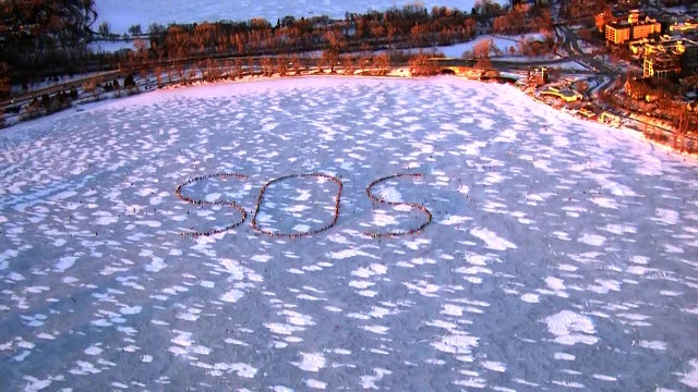 Lake Bde Maka Ska gathering creates 'SOS' message made from people