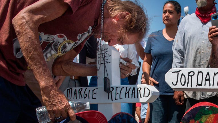 Antonio Basbo kisses the cross with the name of his common-law wife Margie Reckard, who died in El Paso shooting, at a makeshift memorial in El Paso, Texas, on August 5, 2019.