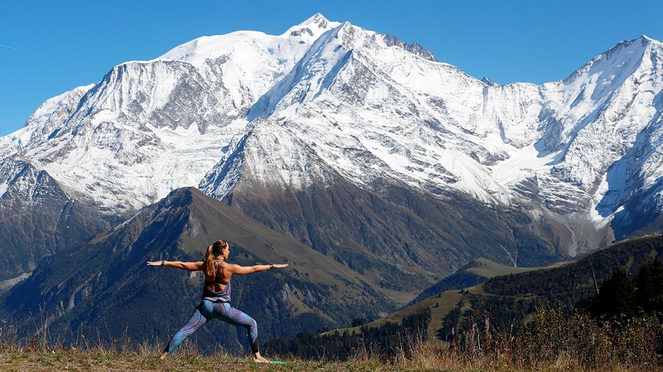 French Alps. Mont-Blanc massif. Woman doing yoya meditation on mountain. Saint-Gervais, France.