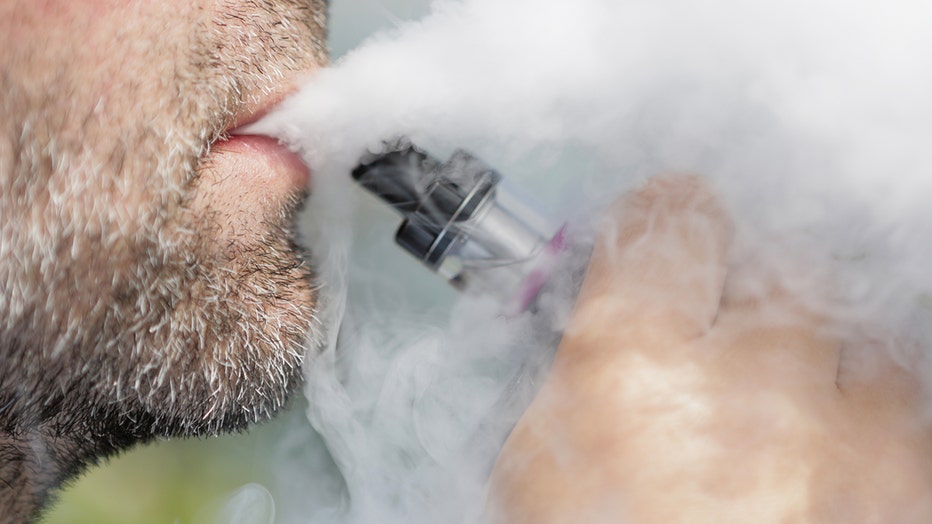 A man smokes an e-cigarette. Vaporizer devices like this, including those that contain THC, are causing an uptick in illnesses reported by users.