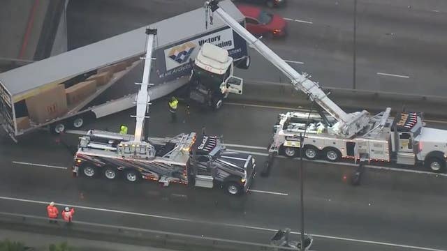 Big rig dangles off connector ramp on 710 Freeway during morning rush hour on rainy day