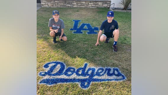 Brothers show their Dodgers spirit spray painting team logos on lawns across Southern California