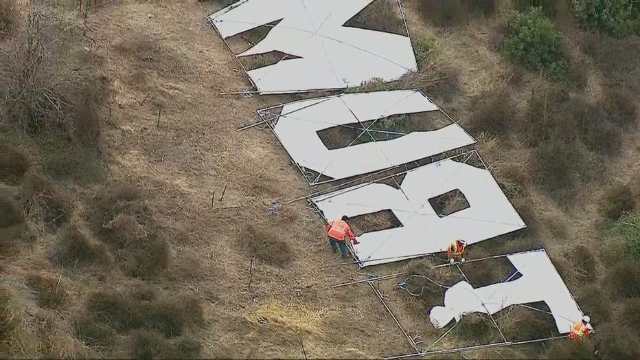 A large sign that read 'Trump' being removed from the hillside next to the 405 Freeway