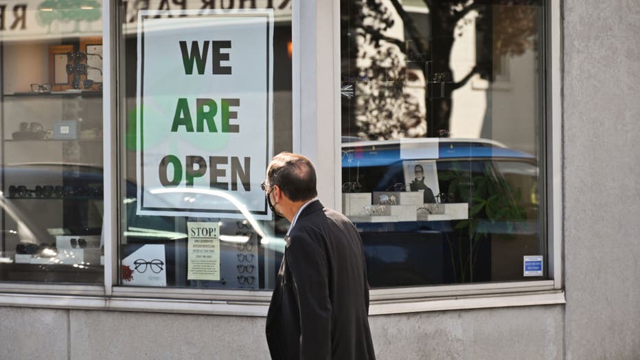 Man reads sign in business window that says, 