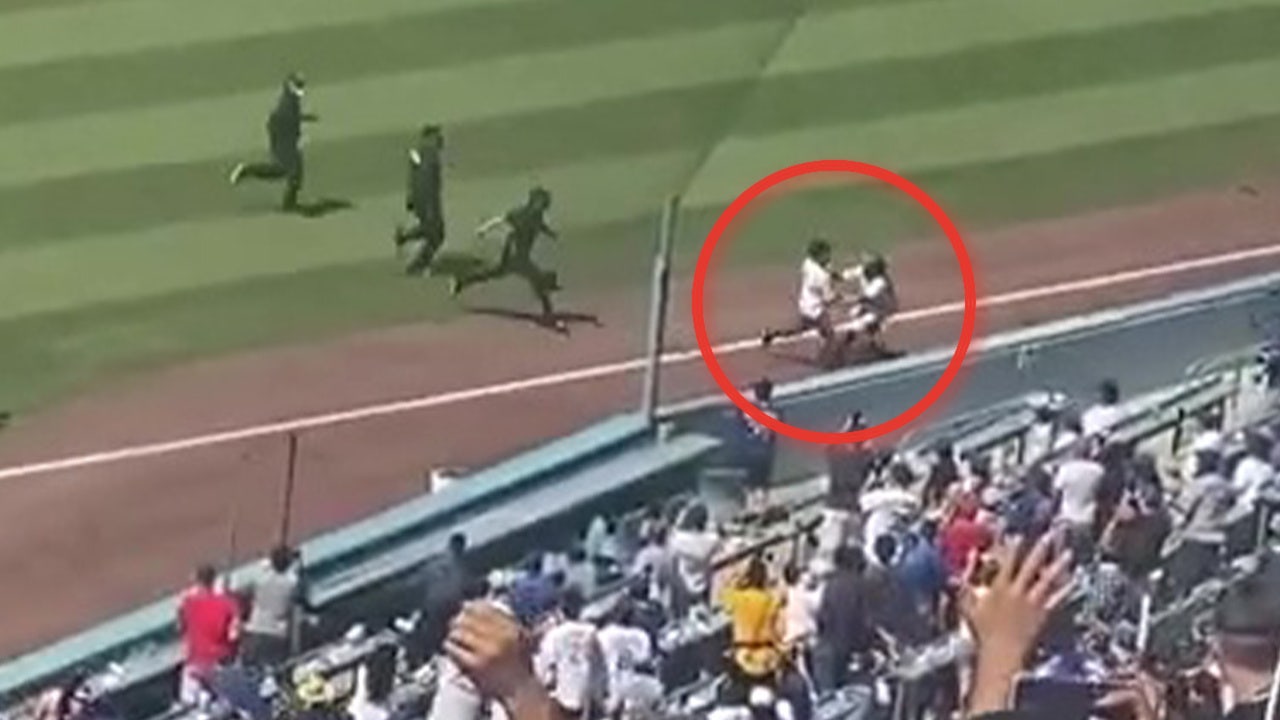 VIDEO: LA Dodgers' ball girl tackles pitch invader during crosstown rivalry  game