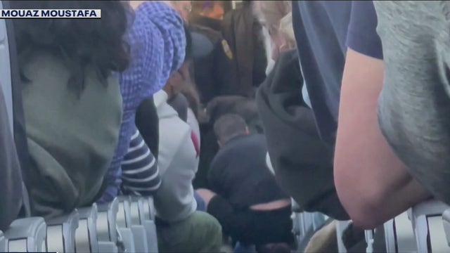 Flight attendants and passengers subdue unruly man who reportedly tried to open plane door, enter cockpit