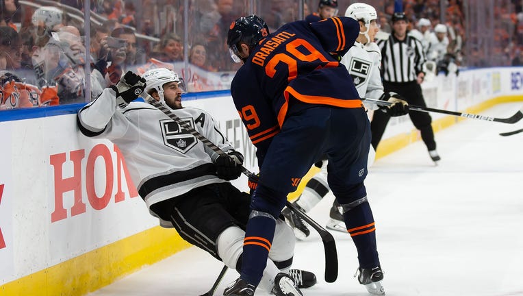 PHOTO: Kings mascot offers Oilers 'Hockey for Dummies' book during blowout