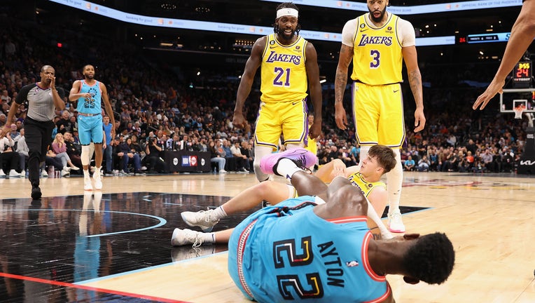 Patrick Beverley #21 of the Los Angeles Lakers reacts after pushing Deandre Ayton #22 of the Phoenix Suns to the ground, alongside Anthony Davis #3 and Austin Reaves #15. PHOTO: Christian Petersen/Getty Images