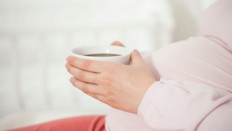 5a4b351d-Schwangere mit Tasse Kaffe/Tee