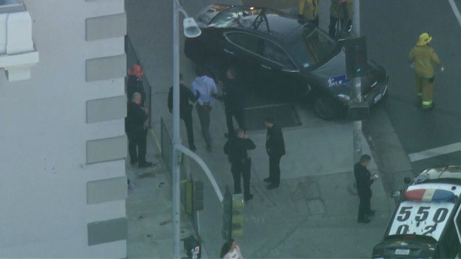 Police detain a police chase suspect and lead him over to a patrol vehicle.