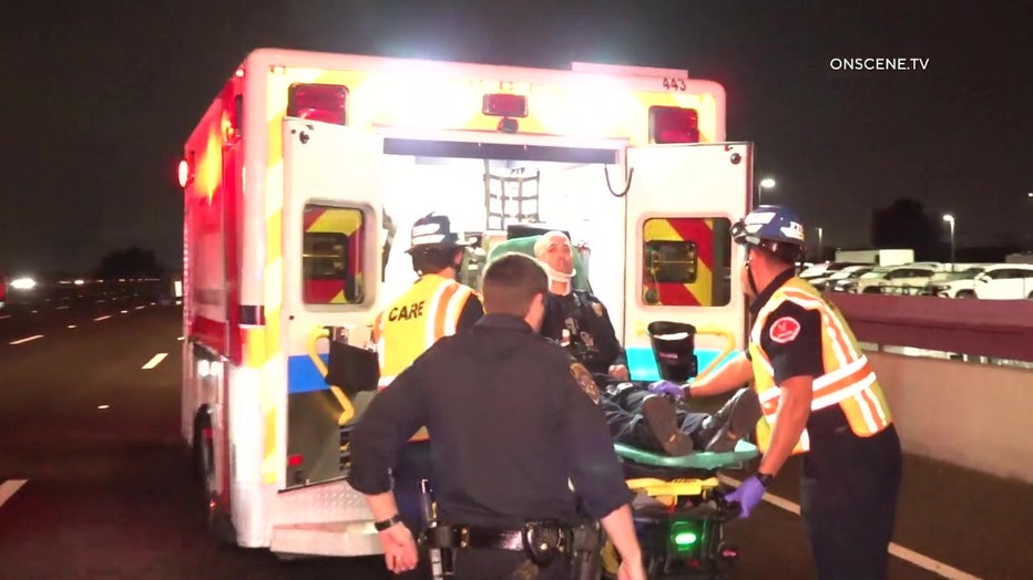 An injured CHP officer is loaded into an ambulance on a gurney