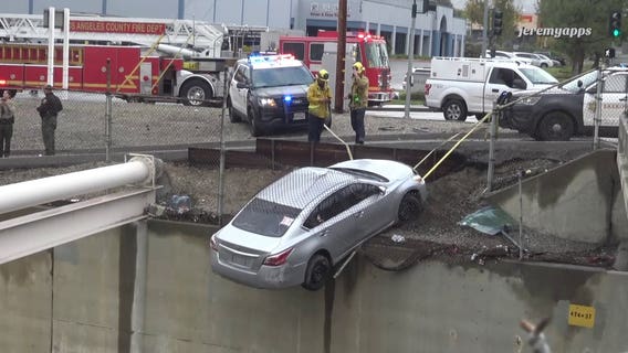 Car nearly falls off edge, hangs over wash in City of Industry