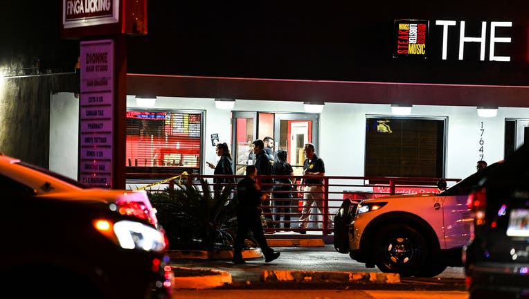 Miami Gardens Police officers walk out of the The Licking restaurant in Miami Gardens, Florida, on January 5, 2023. - Multiple people were shot Thursday night outside of a restaurant during a video shoot for rappers French Montana and Rob49. (Photo by CHANDAN KHANNA/AFP via Getty Images)