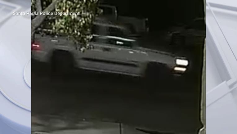 A surveillance camera photo of a blurry white Chevrolet Tahoe