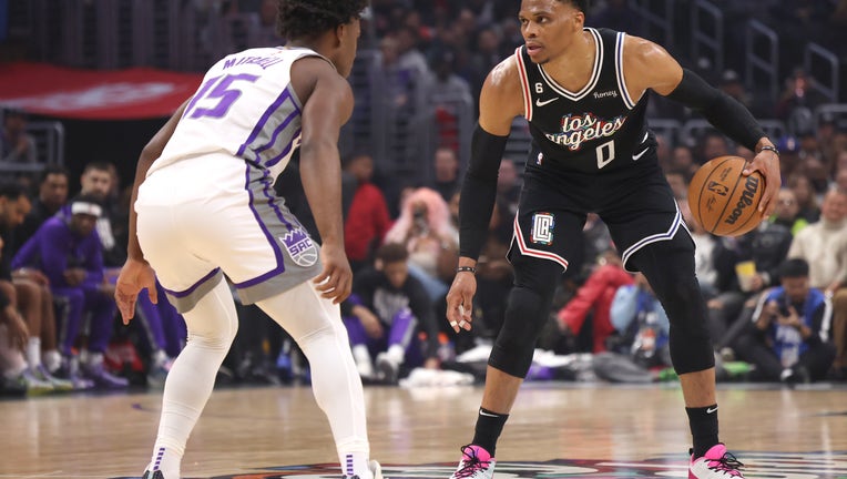 Russell Westbrook #0 of the LA Clippers dribbles in front of Davion Mitchell #15 of the Sacramento Kings during the first half at Crypto.com Arena on February 24, 2023 in Los Angeles, California. (Photo by Harry How/Getty Images)