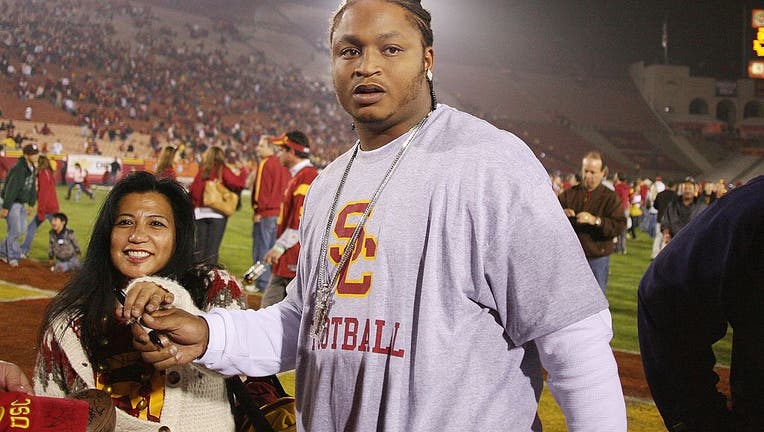 LenDale White of the Tennessee Titans signs autographs for fans on the field after the game between the Notre Dame Fighting Irish and the USC Trojans on November 29, 2008 at the Los Angeles Memorial Coliseum. USC won 38-3. (Photo by Jeff Golden/Getty Images)