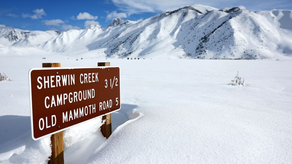 A road sign is partially buried in snow in the Sierra Nevada mountains after yet another storm system brought heavy snowfall to higher elevations further raising the snowpack on March 30, 2023 near Mammoth Lakes, California.