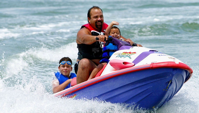 A-man-enjoys-time-on-a-jet-ski-with-his-sons.jpg