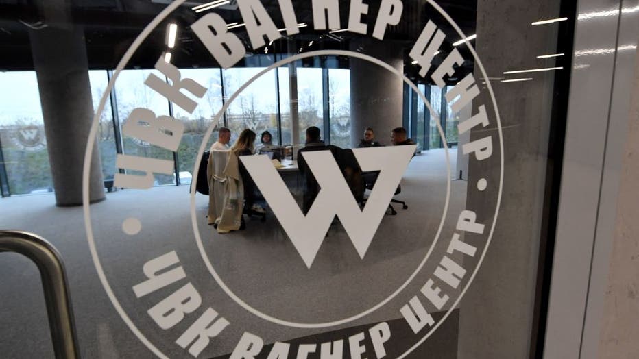 People sit at the desk in the office in the 'PMC Wagner Centre', associated with the founder of the Wagner private military group (PMC) Yevgeny Prigozhin, during the official opening of the office block on the National Unity Day, in Saint Petersburg, on November 4, 2022. (Photo by Olga MALTSEVA / AFP) (Photo by OLGA MALTSEVA/AFP via Getty Images)