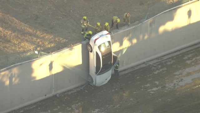 Mercedes-Benz barely hangs onto fence after going off edge in LA's Valley Glen