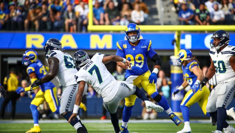 Los Angeles Rams defensive tackle Aaron Donald (99) pressures Seattle Seahawks quarterback Geno Smith (7) during the Seattle Seahawks vs Los Angeles Rams game on November 19, 2023, at SoFi Stadium in Inglewood, CA. (Photo by Jevone Moore/Icon Sportswire via Getty Images)