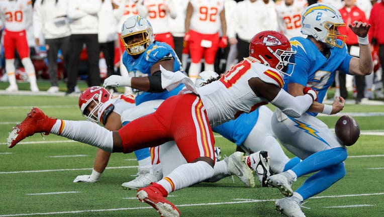 Charles Omenihu #90 of the Kansas City Chiefs sacks and forces Easton Stick #2 of the Los Angeles Chargers to fumble resulting in a Kansas City Chiefs defensive touchdown in the first quarter during a game at SoFi Stadium on January 07, 2024 in Inglewood, California. (Photo by Kevork Djansezian/Getty Images)