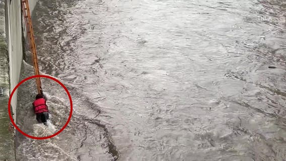 Woman rescued from surging LA River after trying to recover friend's phone
