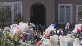 Piles of trash starting to be removed from yard of home in Fairfax District