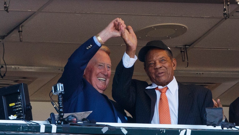 Broadcaster Vin Scully (left) is congratulated on his final broadcast by hall of famer Willie Mays during the fourth inning between the San Francisco Giants and the Los Angeles Dodgers at Oracle Park on October 2, 2016 in San Francisco, California. The San Francisco Giants defeated the Los Angeles Dodgers 7-1. (Photo by Jason O. Watson/Getty Images)