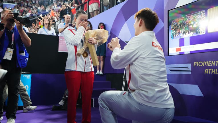 Badminton player Liu Yuchen proposes to gold medalist Huang Yaqiong after the medal ceremony following the Mixed Doubles Gold Medal Match on day seven of the Olympic Games Paris 2024 at Porte de La Chapelle Arena on August 2, 2024 in Paris, France. (Photo by Zhao Wenyu/China News Service/VCG via Getty Images)