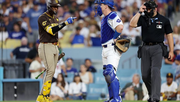 Jurickson Profar #10 of the San Diego Padres and Will Smith #16 of the Los Angeles Dodgers meet in the sixth inning during Game Two of the Division Series at Dodger Stadium on October 06, 2024 in Los Angeles, California. (Photo by Harry How/Getty Images)