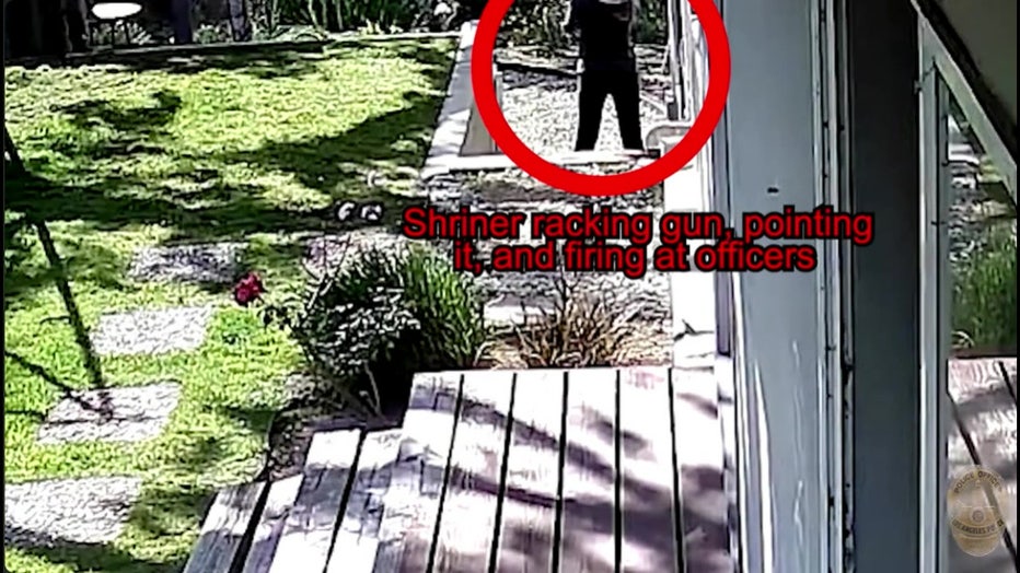 A screenshot of security footage showing a woman near the top of the screen, raising her arms toward a fence. A red circle around her reads 'Shriner racking gun, pointing it, and firing at officers.'