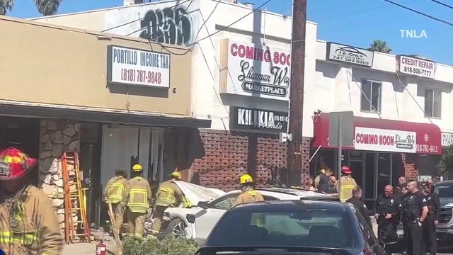 Man trapped after car crashes into building in Valley Glen