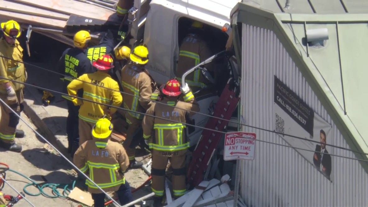 LIVE: Truck crashes into building on PCH; firefighters working to rescue trapped driver