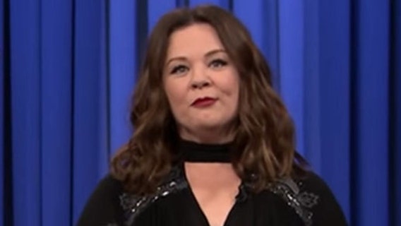 Melissa McCarthy as Sean Spicer cruising on podium in NYC